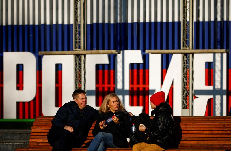 FILE PHOTO: People rest on a bench in Moscow