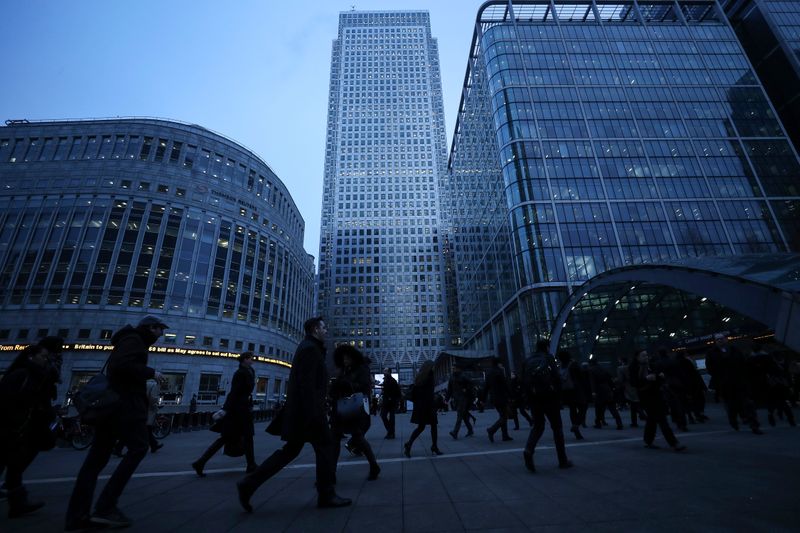 FILE PHOTO: Workers walk to work during the morning rush hour in the financial district of Canary Wharf in London