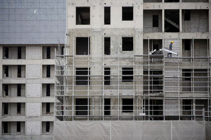 A worker walks on scaffolding at a construction site in Shanghai