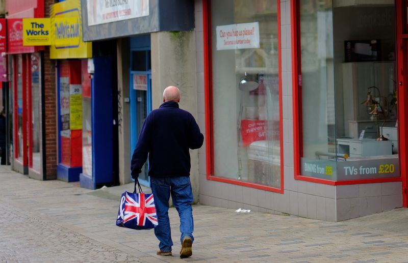 FOTO DE ARCHIVO. Un hombre lleva una bolsa de compras mientras camina por una calle comercial vacía en Blackpool, Reino Unido