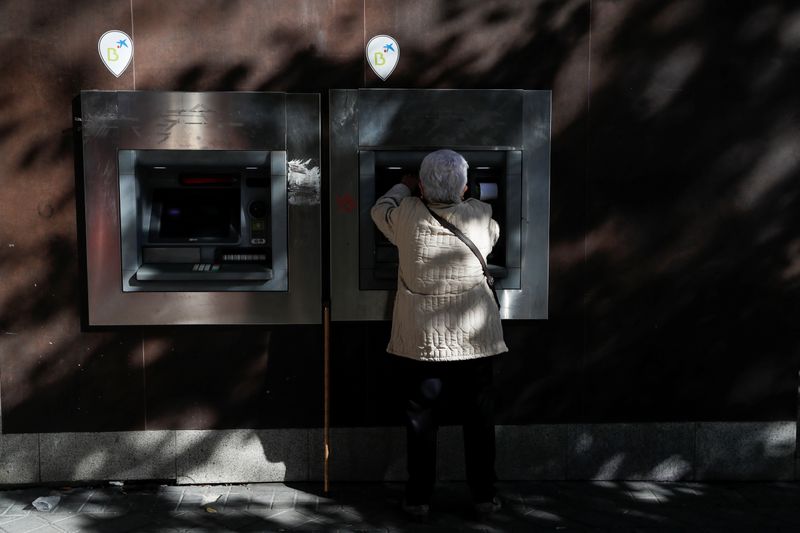 Woman uses Caixabank ATM machine in Madrid
