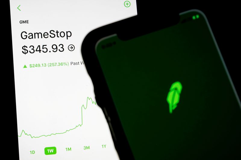 FILE PHOTO: Trading information for GameStop is displayed on the Robinhood App as another screen displays the Robinhood logo