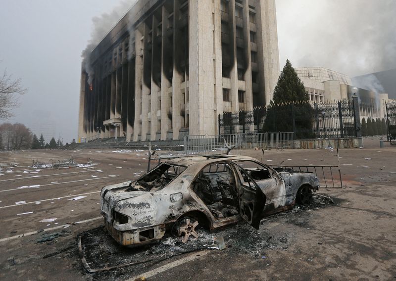 FILE PHOTO: A burned car is seen in front of the mayor's office building which was torched during protests in Almaty