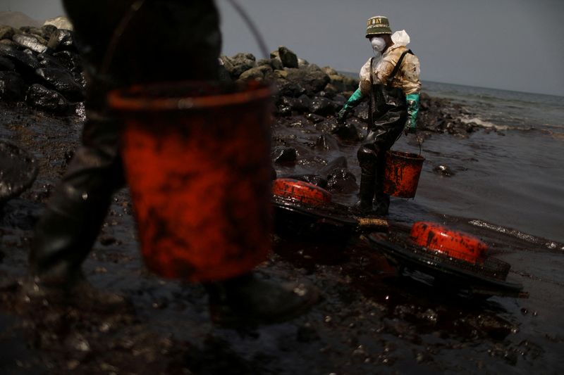 Foto del martes de trabajadores limpiando petróleo tras un derrame en la zona de Ancon, Peru 