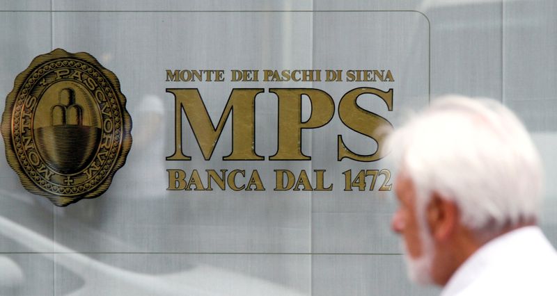 A man walks in front of Monte Dei Paschi di Siena bank in downtown Milan