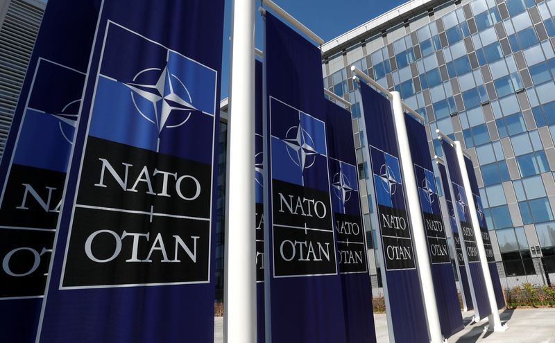 Banners displaying the NATO logo are placed at the entrance of new NATO headquarters during the move to the new building