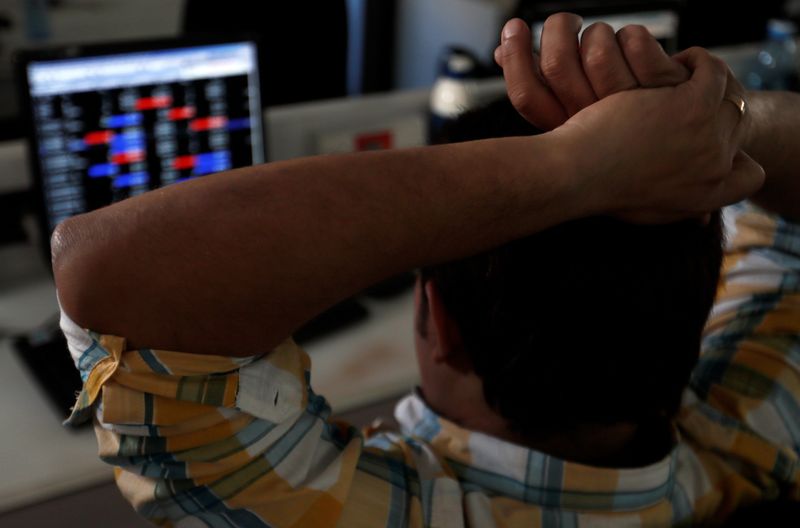 FILE PHOTO: Broker reacts while trading at his computer terminal at a stock brokerage firm in Mumbai