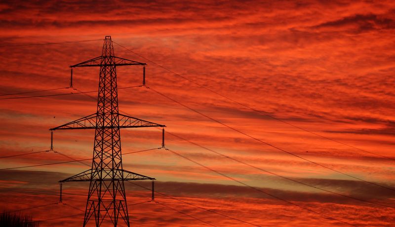 The sun rises behind an electricity pylon in Manchester