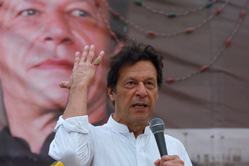 PTI chairman Imran Khan  gestures while addressing his supporters during a campaign meeting ahead of general elections in Karachi