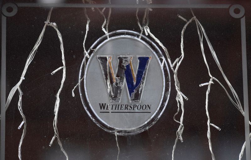 Signage is seen on a window of a closed Wetherspoon pub, London