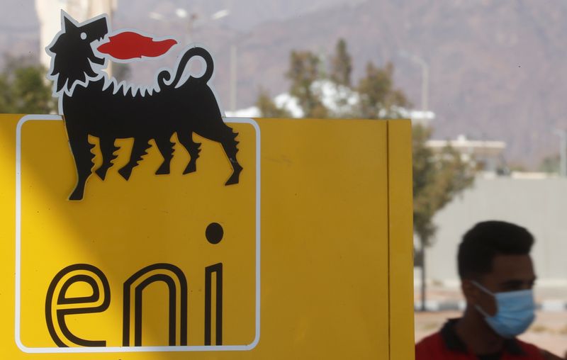 Un uomo con indosso una mascherina cammina vicino all'insegna di Eni presso una stazione di servizio a Sharm el-Sheikh