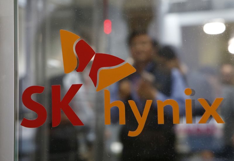 FILE PHOTO: Employees walk past the logo of SK Hynix at its headquarters in Seongnam
