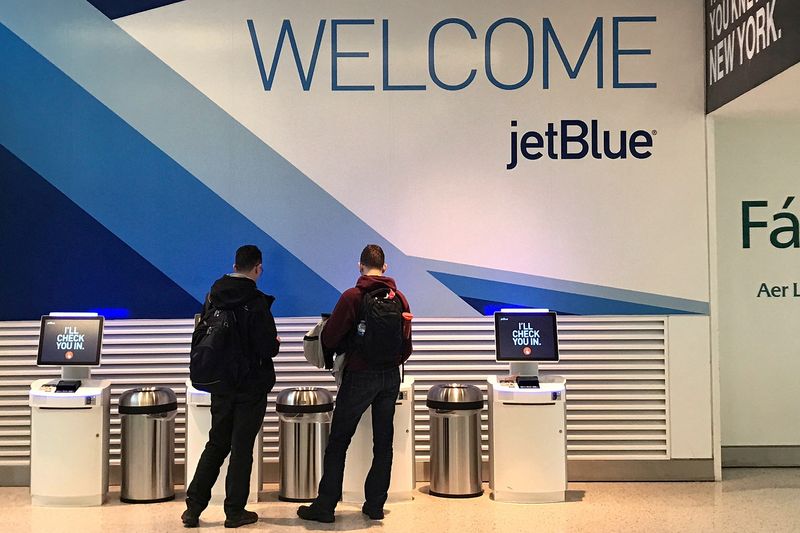 FILE PHOTO: Travelers check-in at a JetBlue Airways kiosk at John F. Kennedy Airport in the Queens borough of New York