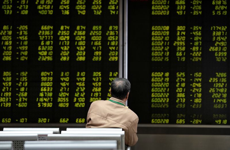 An investor watches a board showing stock information at a brokerage office in Beijing