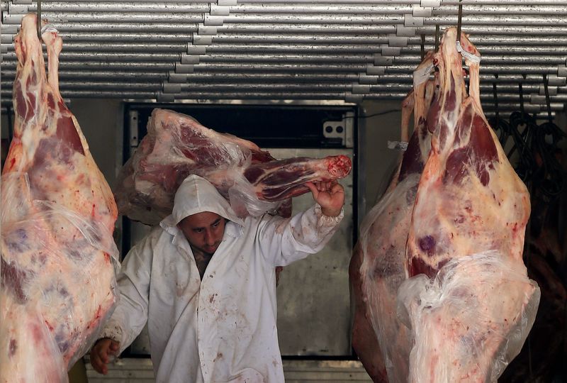 FILE PHOTO: A butcher unloads beef from a truck outside a butcher's shop in Sao Paulo