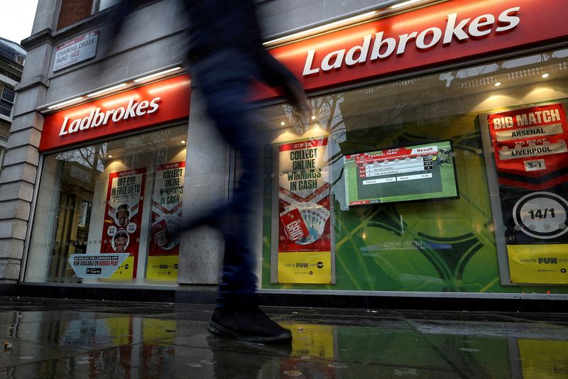 FILE PHOTO: A pedestrian walks past a branch of Ladbrokes in London