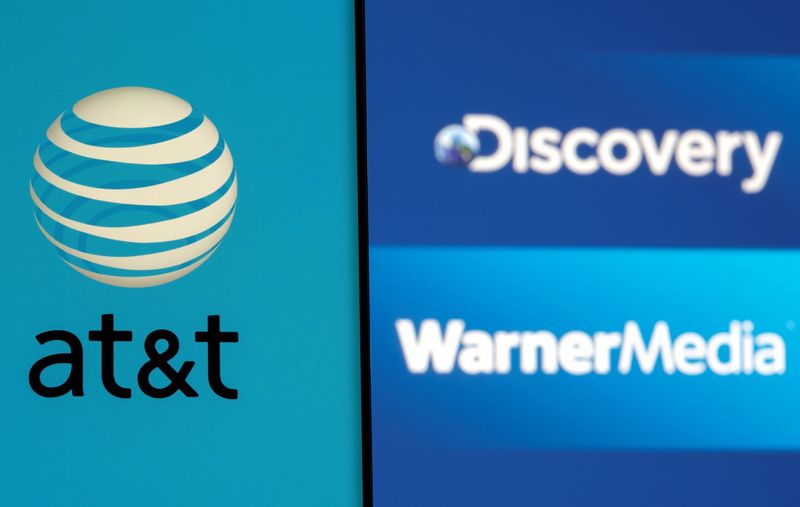 FILE PHOTO: AT&T logo is seen on a smartphone in front of displayed Discovery and Warner Media logos in this illustration