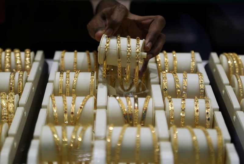 A salesman arranges gold bangles inside a jewellery showroom on the occasion of Akshaya Tritiya, a major gold buying festival, in Mumbai