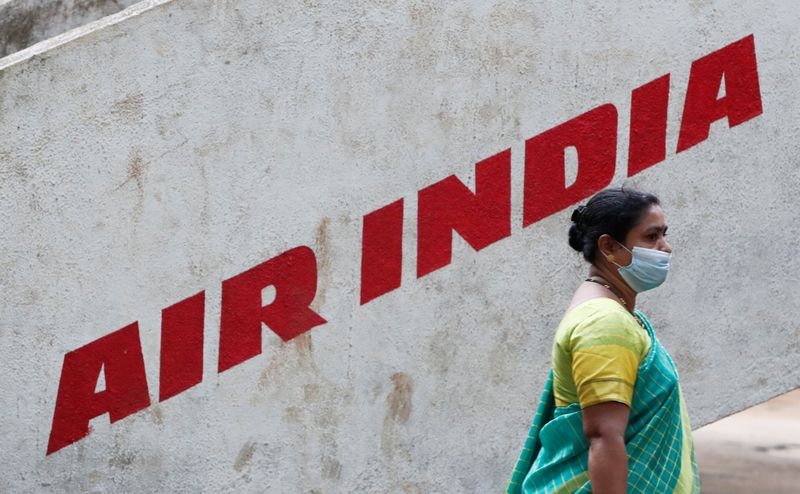 FILE PHOTO: A woman walks past Air India airlines branding at a park in Mumbai
