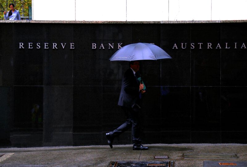 FILE PHOTO: Pedestrians walk past the Reserve Bank of Australia building in central Sydney, Australia