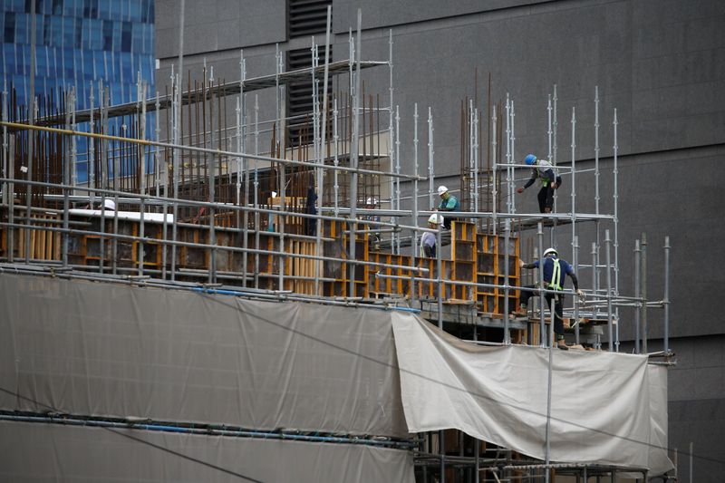 Workers labour on steel frames at a construction site in central Seoul