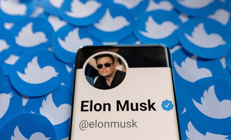 FILE PHOTO: FILE PHOTO: Illustration shows Elon Musk's Twitter profile on smartphone and printed Twitter logos