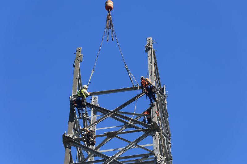 FILE PHOTO: Workers set up a high-voltage power line for Amprion near Duesseldorf