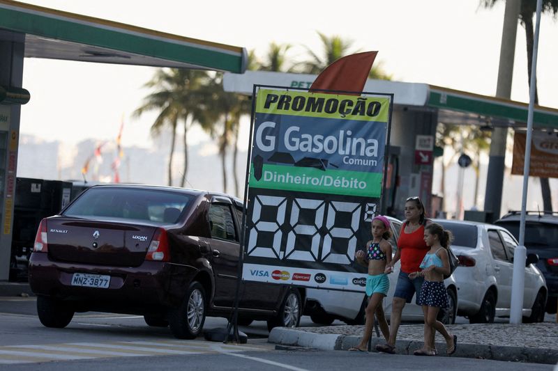 FOTO DE ARCHIVO: Gente camina mientras autos hacen fila en una gasolinera de Río de Janeiro