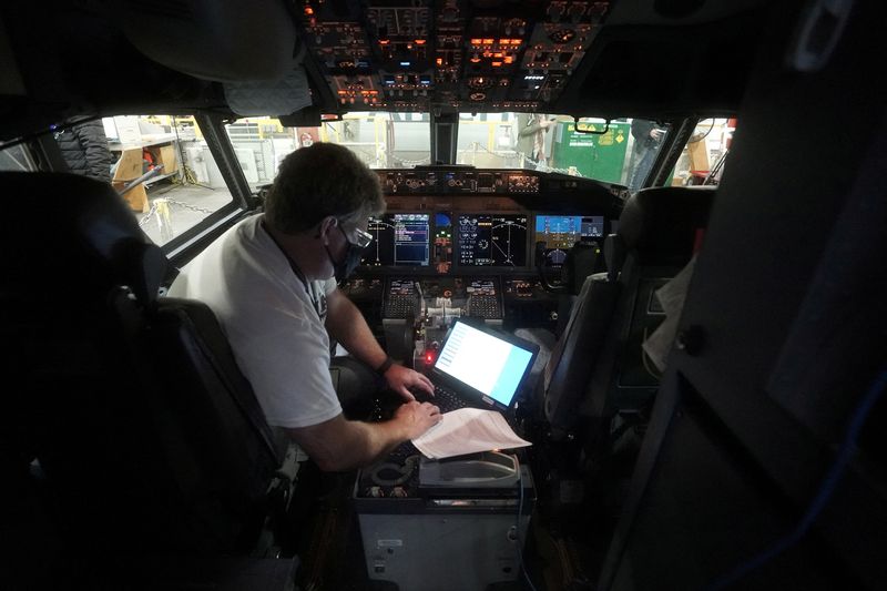 FILE PHOTO: A worker loads new software into the Boeing 737 Max airplane in a maintenance hangar in Tulsa