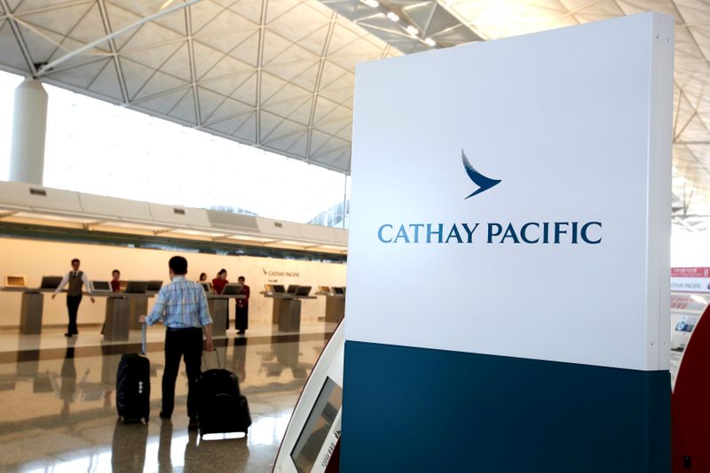 FILE PHOTO: A passenger walks to the First Class counter of Cathay Pacific Airways at Hong Kong Airport in Hong Kong