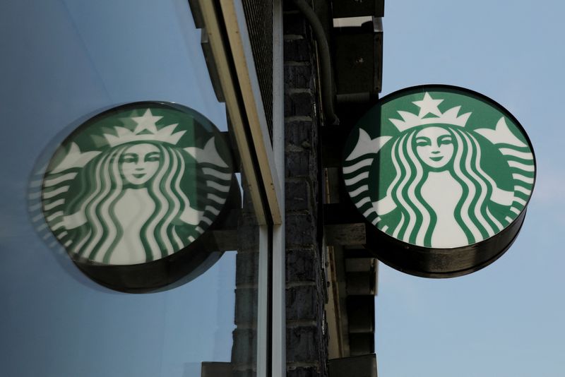 FILE PHOTO: A Starbucks logo hangs outside of one of the 8,000 Starbucks-owned American stores that will close around 2 p.m. local time on Tuesday as a first step in training 175,000 employees on racial tolerance in the Brooklyn borough of New York