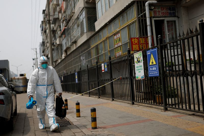 ARCHIV: Ein Arbeiter in einem Schutzanzug trägt eine Desinfektionsausrüstung in Peking, China, 29. April 2022. REUTERS/Carlos Garcia Rawlins