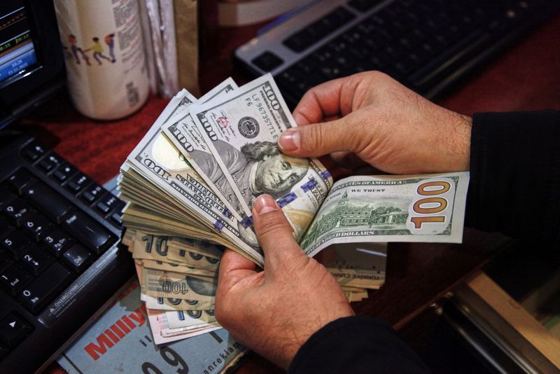 FILE PHOTO: A money changer counts U.S. dollar banknotes at a currency exchange office in Ankara