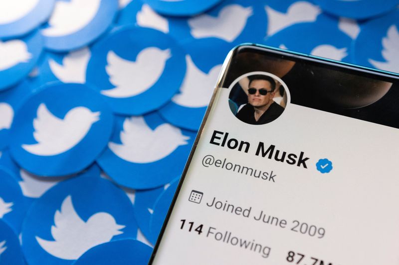 ARCHIV: Das Twitter-Profil von Elon Musk auf einem Smartphone, das auf gedruckten Twitter-Logos platziert ist, 28. April 2022. REUTERS/Dado Ruvic/Illustration