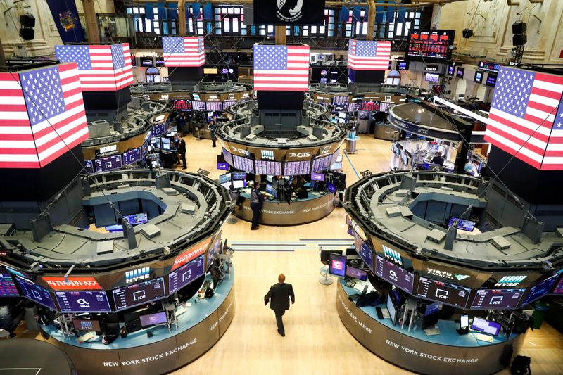 FILE PHOTO: Traders work on the floor of the New York Stock Exchange shortly as coronavirus disease (COVID-19) cases in the city of New York rise