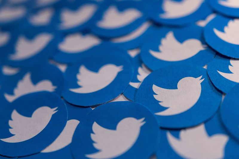 Illustration shows printed Twitter logos