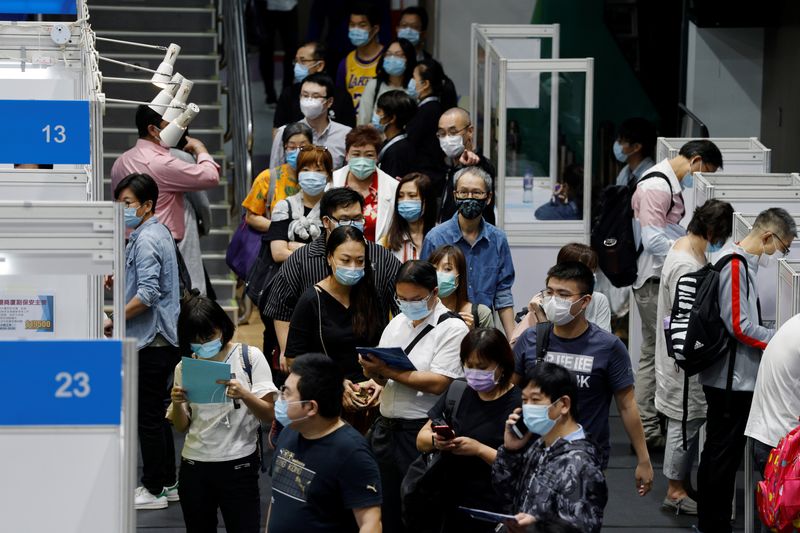 Job seekers wearing face masks fill in forms at the Wan Chai Job Fair, following the coronavirus disease (COVID-19) outbreak, in Hong Kong