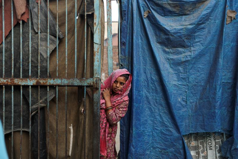 Resident peaks out of her house near the site of the commercial building that caught fire in New Delhi
