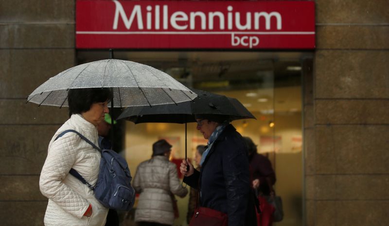 People walk near a branch of Millennium BCP Bank in downtown Lisbon