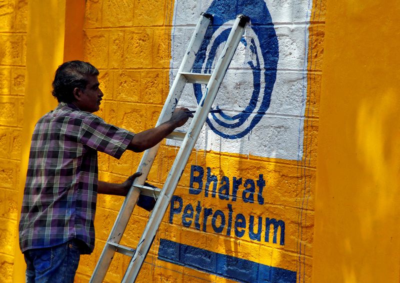 FILE PHOTO: A man paints the logo of oil refiner Bharat Petroleum Corp on a wall on the outskirts of Kochi