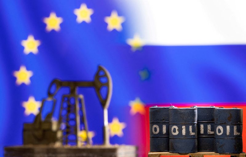 FOTO DE ARCHIVO: Modelos de barriles de petróleo y una bomba de extracción delante de los colores de la bandera de la UE y Rusia 