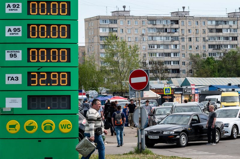 FILE PHOTO: Drivers stay in line outside a petrol station as they try to buy fuel in Kyiv