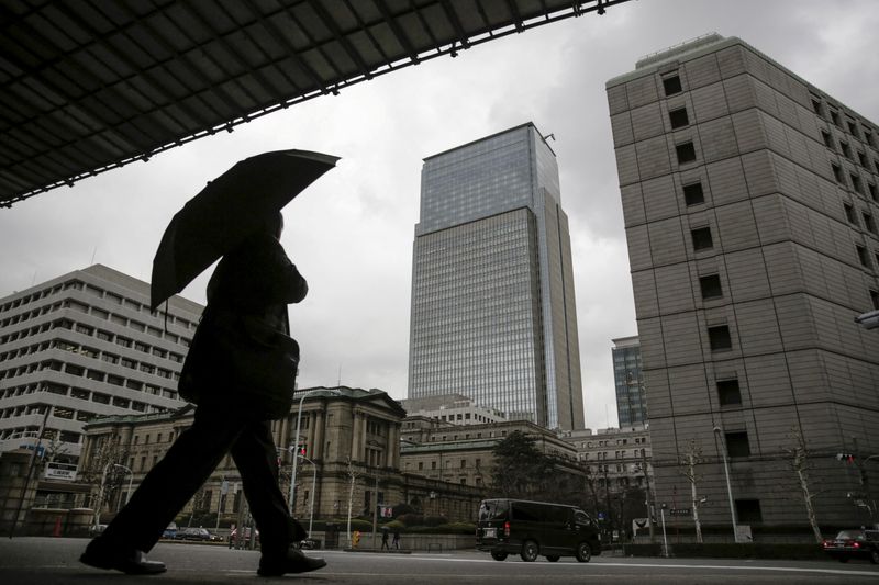 FILE PHOTO: A businessman walks near the Bank of Japan headquarters in Tokyo