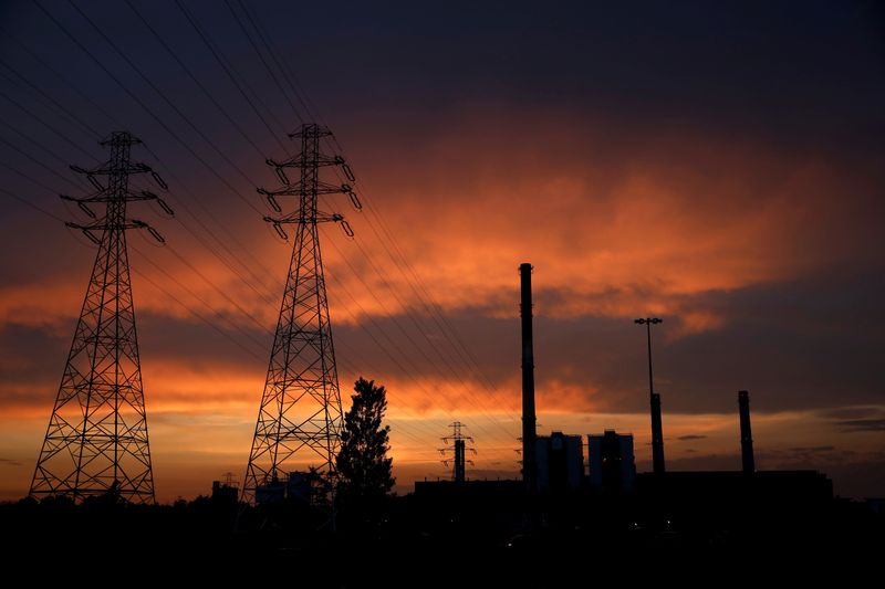 FILE PHOTO: Electric poles are pictured in front of the PGNiG Termika Zeran thermal power station after sunset in Warsaw