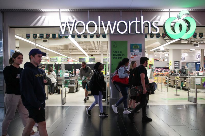 FILE PHOTO: People walk past a Woolworths supermarket in Sydney