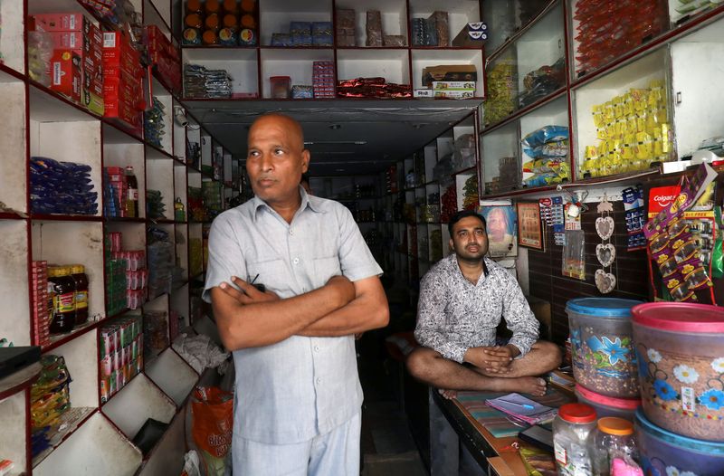 Shopkeeper looks on as he waits for customers at Kasan village in Manesar