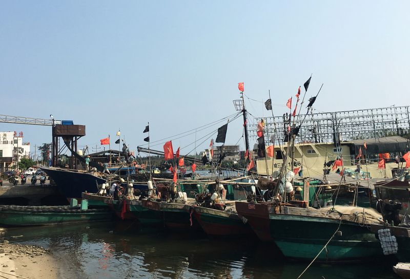 Fishing boats with Chinese national flags are seen at a harbour in Tanmen, Hainan province