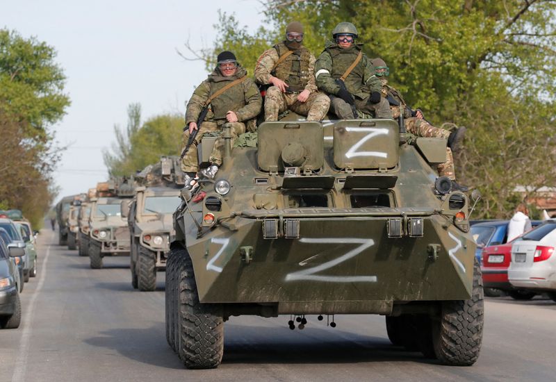 Service members of pro-Russian troops ride an armoured personnel carrier in Bezimenne