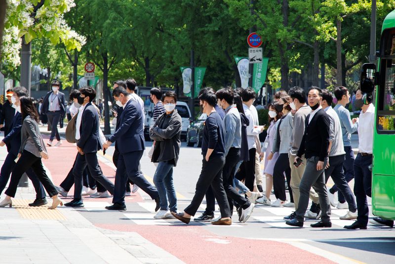 FILE PHOTO: People wear masks to prevent the spread of the coronavirus disease (COVID-19) as they walk on zebra crossing in Seoul