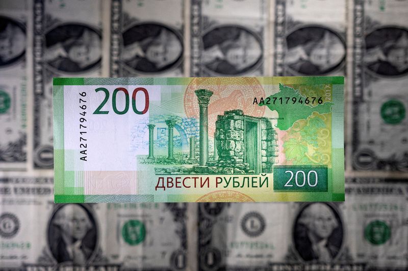 FILE PHOTO: Illustration shows a Russian rouble banknote placed on U.S. dollar banknotes